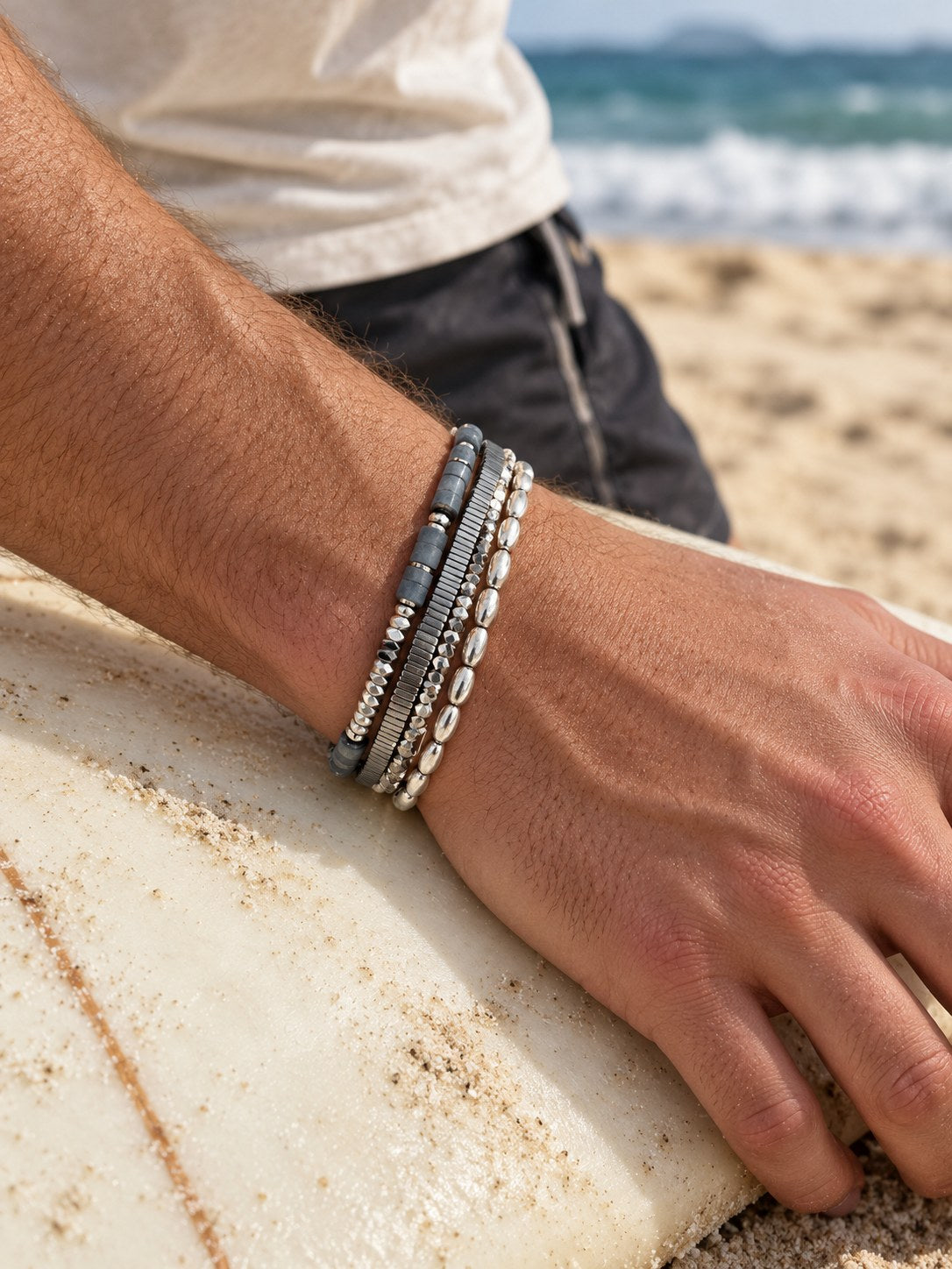 The Aqua Set on the wrist, on a surfboard
