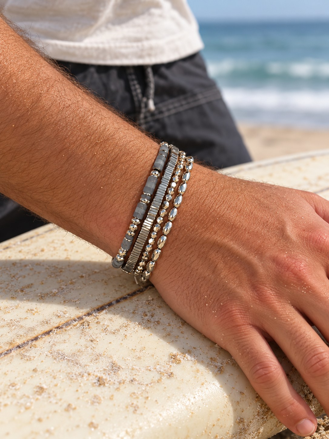 The Aqua Set on the wrist, on a surfboard