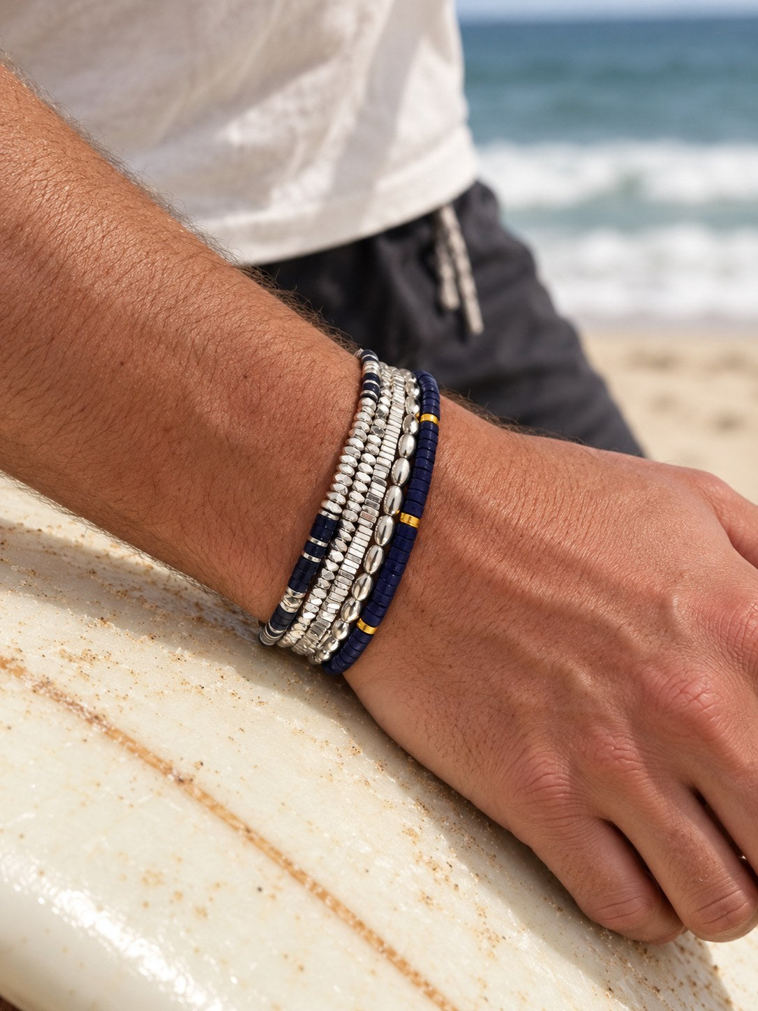 The Lapis Set on the wrist, on a surfboard